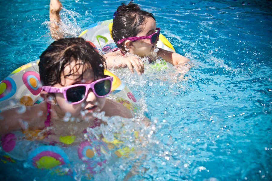 twee jongen meisjes zwemmen in zwembad