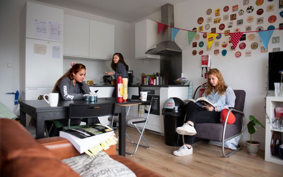 drie vrouwen aan tafel in een woonkamer