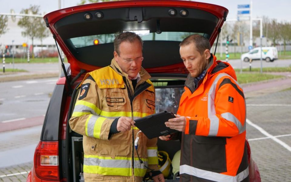 twee brandweer functionarissen overleggen met ipad