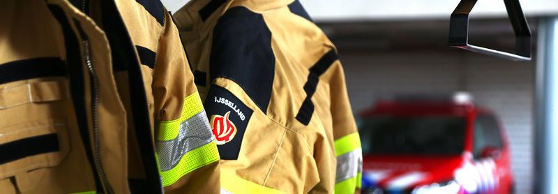 blusjassen met brandweerauto op achtergrond