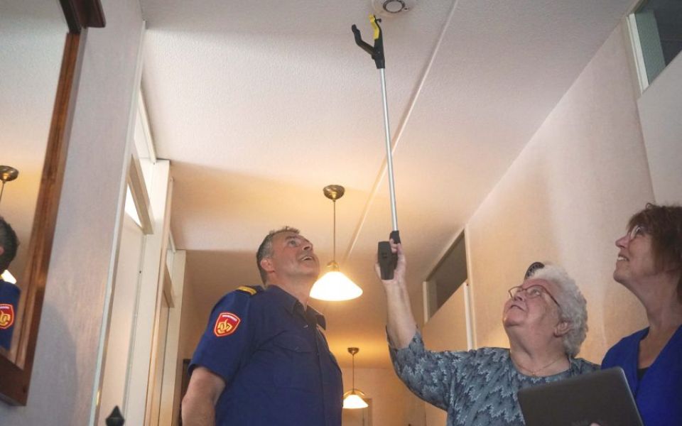 oudere vrouw installeert zelf brandmelder