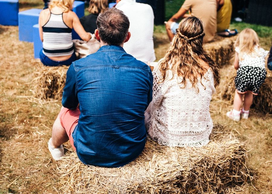 de achterkant van man en vrouw zittend op hooibaal