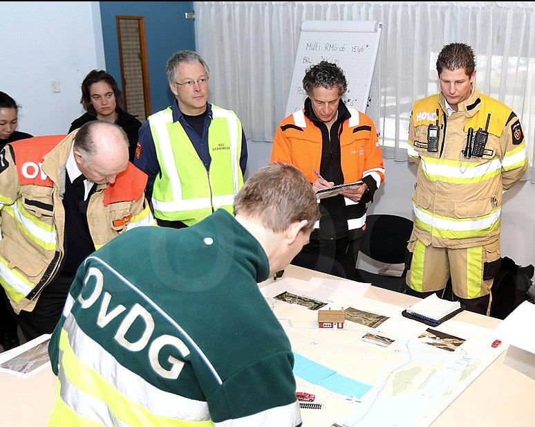 overleg van meerdere functionarissen kijkend naar informatiekaart