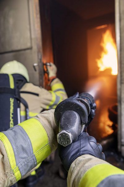 inzet brandweer met straalpijp in container