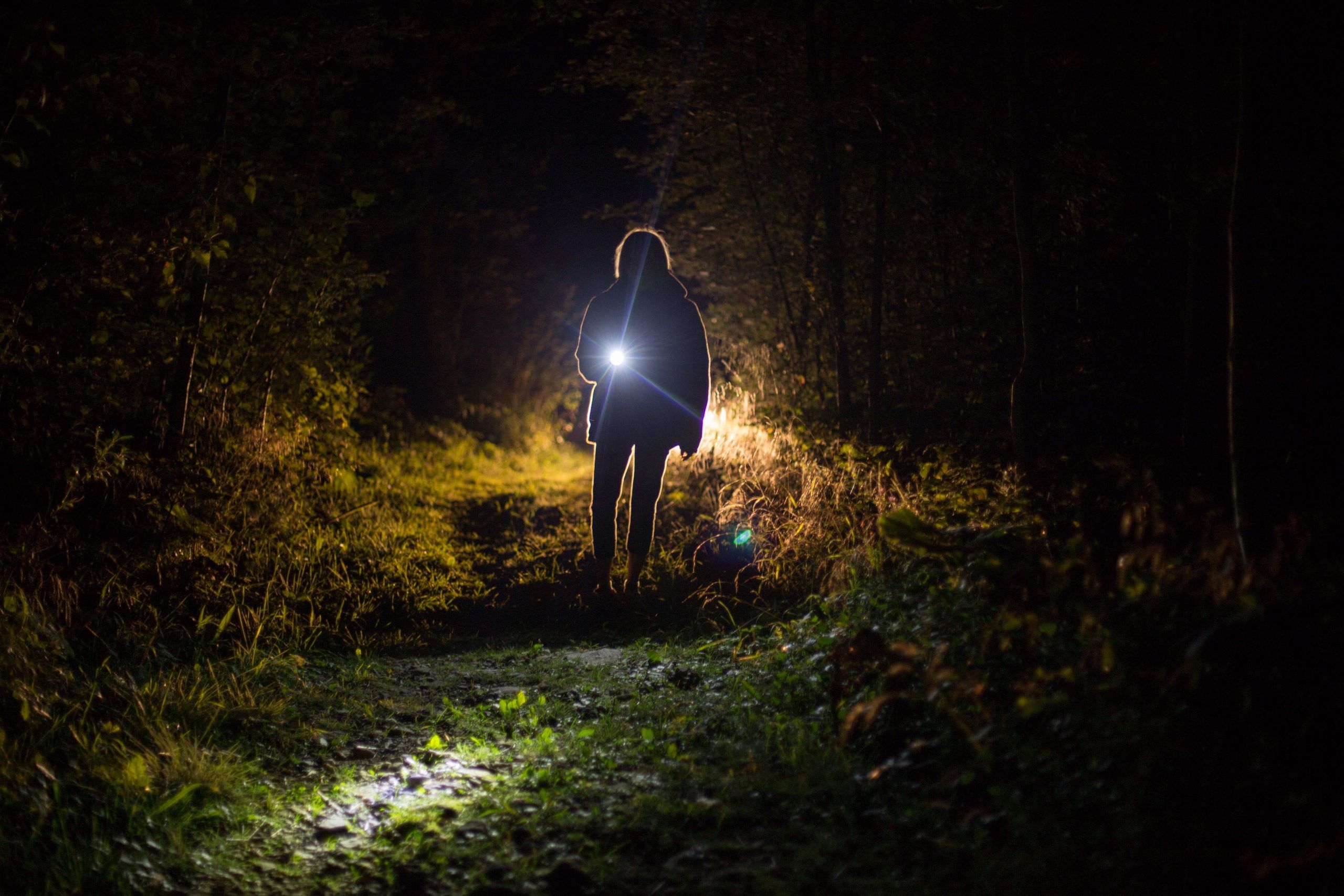 vrouw met zaklamp in donker