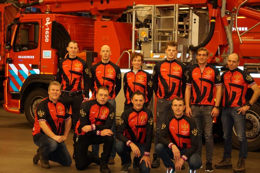 groepsfoto voor brandweerauto van brandweermensen die Alpe d'huzes willen rijden