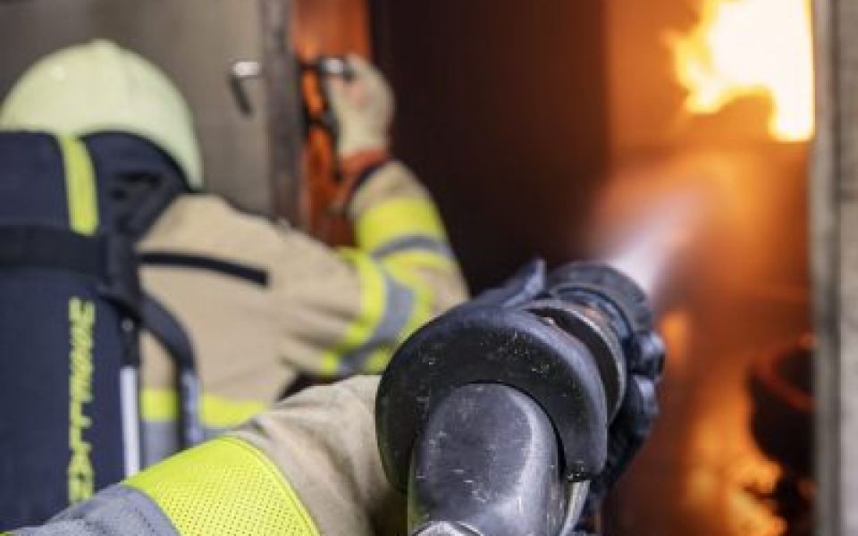 inzet brandweer met straalpijp in container