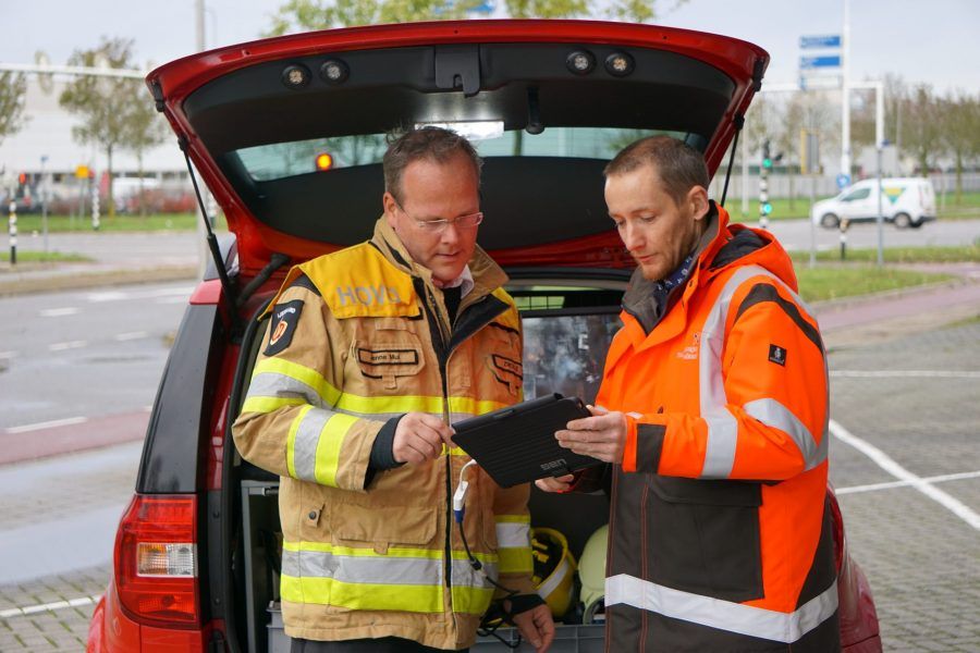 twee brandweer functionarissen overleggen met ipad