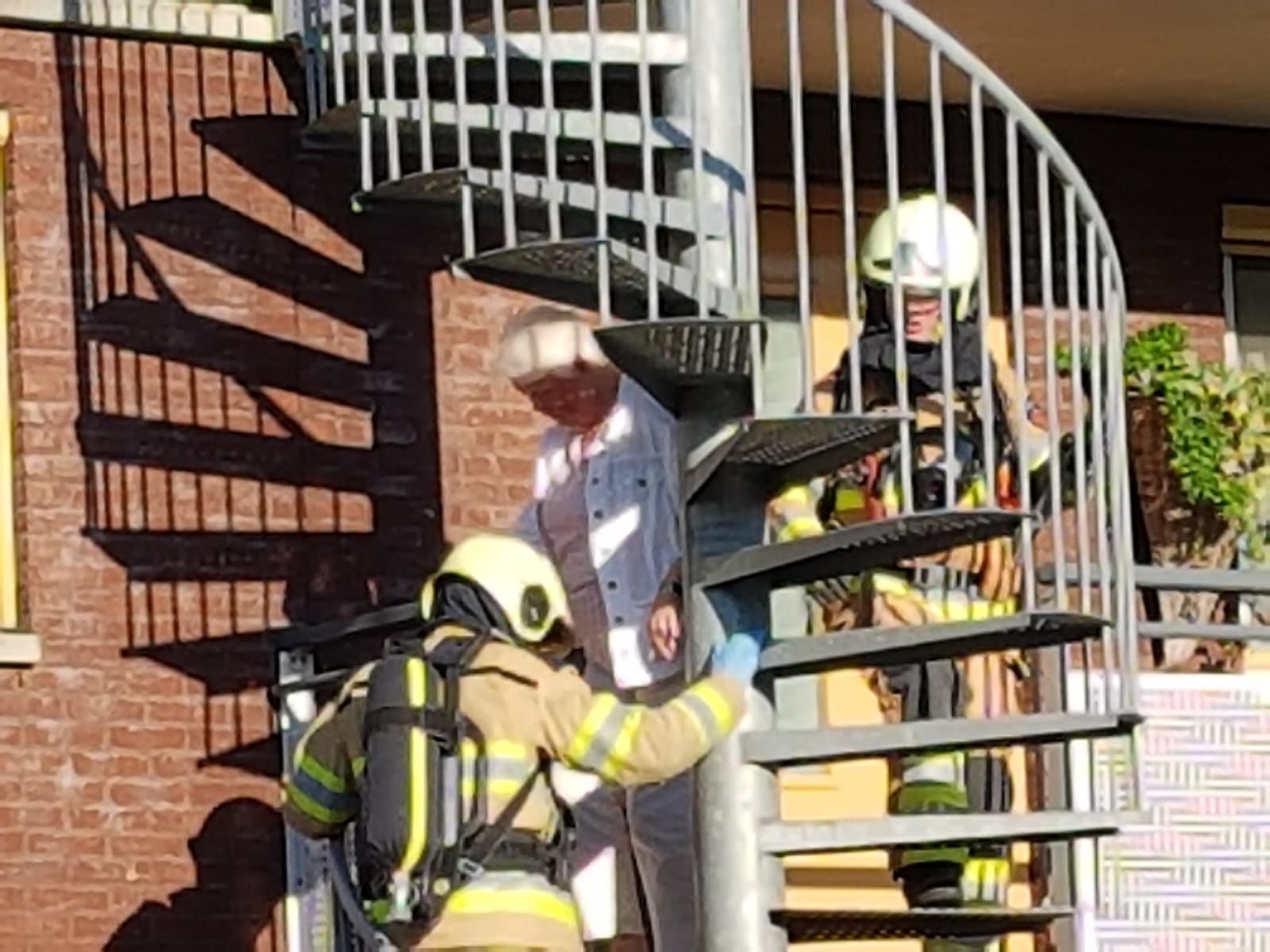 oude dame wordt geëvacueerd door brandweer via brandtrap