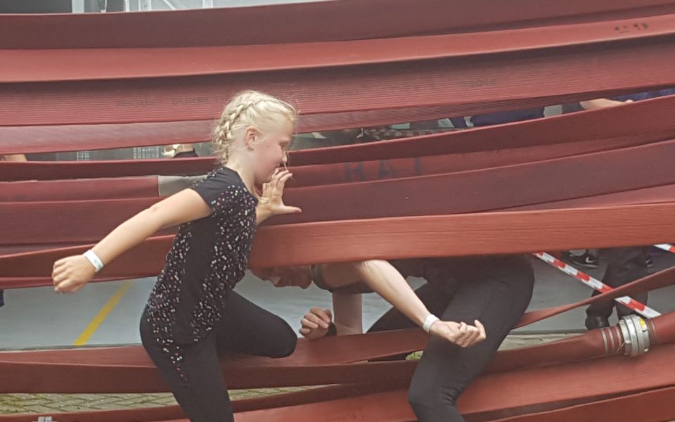 kinderen klimmen door brandweer slangen
