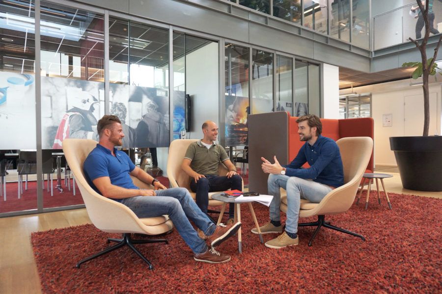 drie mannen overleggen op stoel