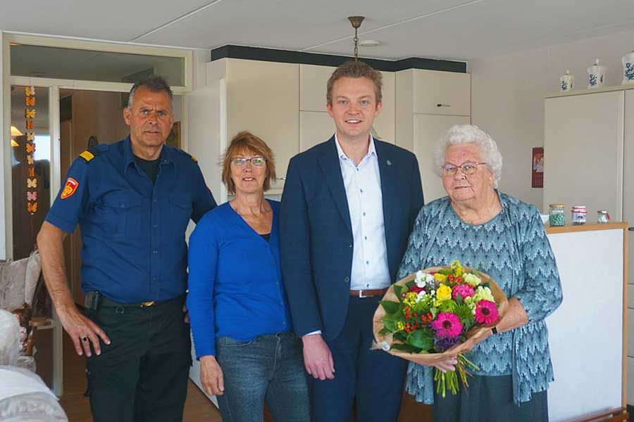 mevrouw troost met brandweerman Roel, begeleider coby en wethouder Mussche