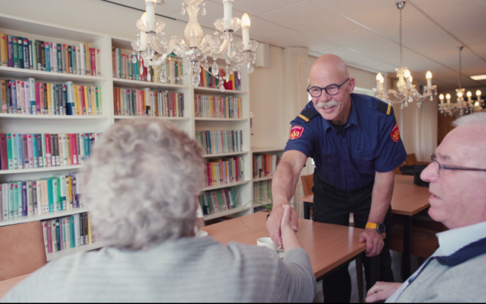 brandweerman geeft vrouw hand