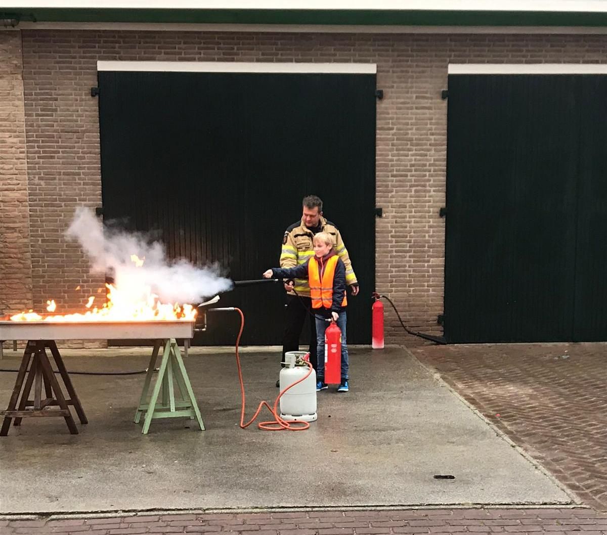 kind blust onder begeleiding brandweerman vuurbak