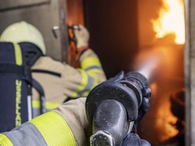 inzet brandweer met straalpijp in container